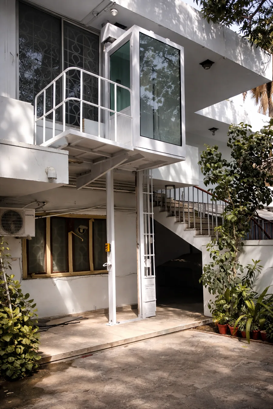GlassCore glass elevator exterior with white frame at a residence