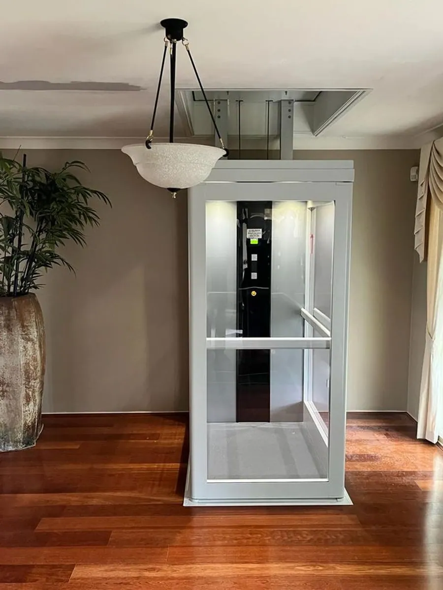 GlassCore glass elevator exterior with white frame at a residence